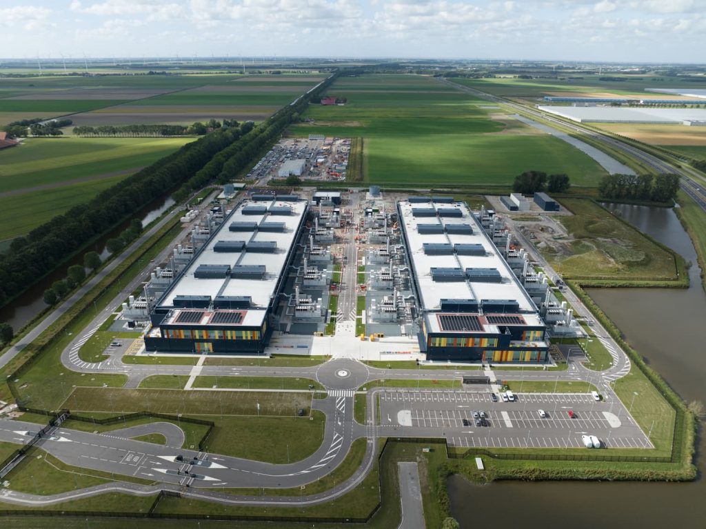 Vista aérea de un gran edificio industrial, específicamente un centro de datos, mostrando su estructura y entorno.